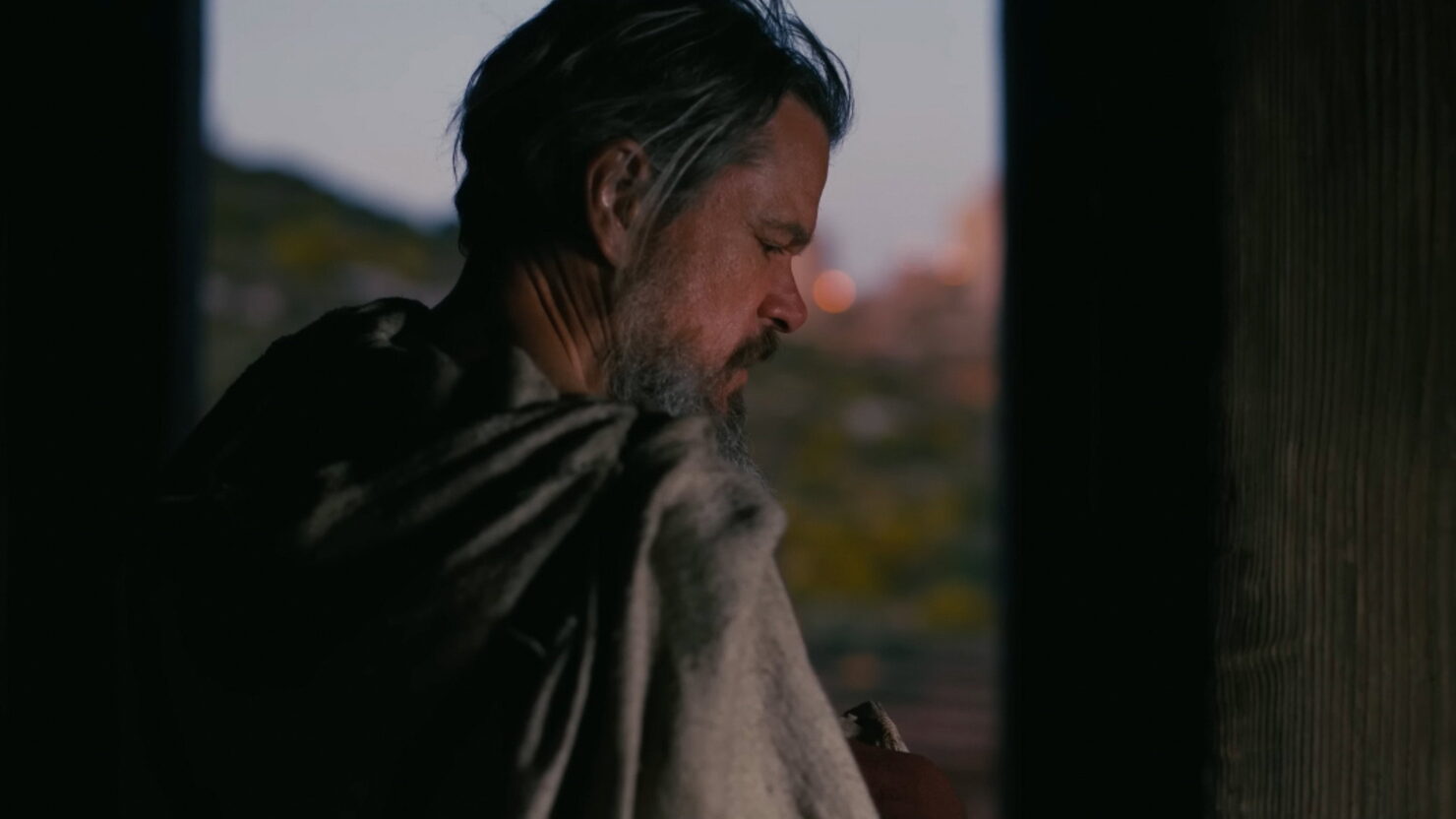 Un uomo osserva il tramonto, scena tratta da Odissea (2026)